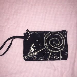 Black flower purse with zipper and handle.